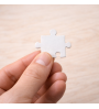 Tassello di puzzle personalizzato tenuto in mano per mostrare le dimensioni